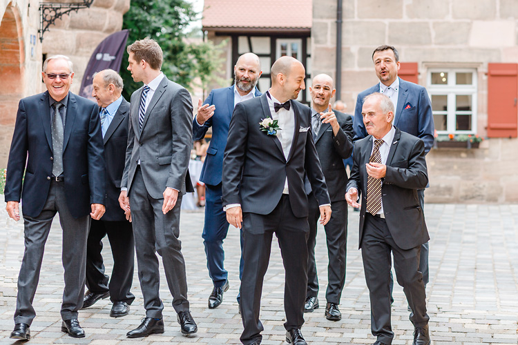 Die Männer laufen auf den Hochzeitsfotografen zu